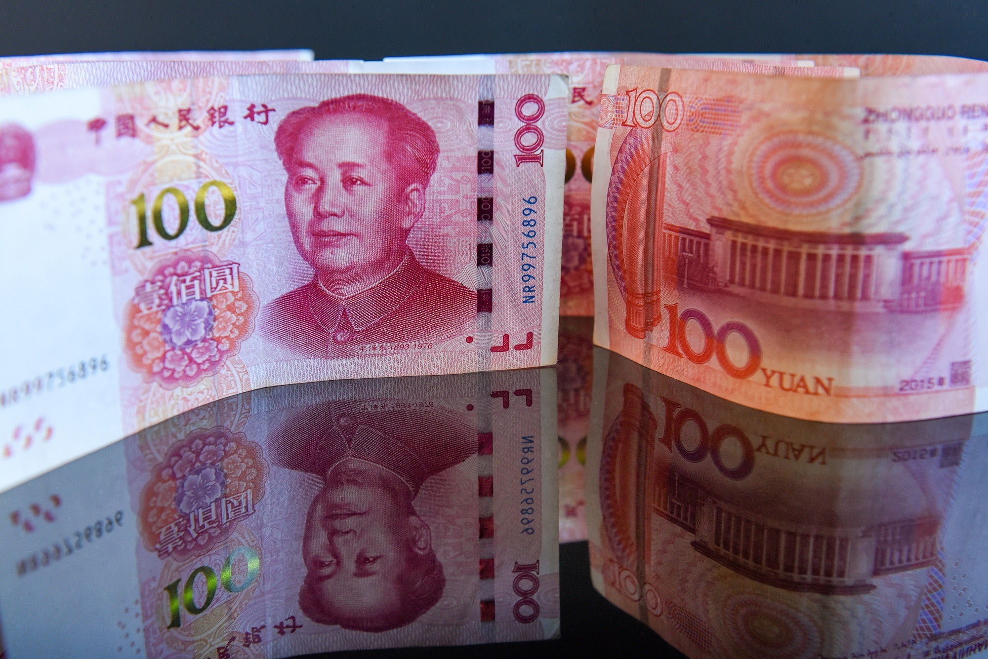 Indoor shoot of Chinese currency - Yuan. No people on the pictures, just different arrangements of the bill of 100 (one hundred) yuan placed on a reflective surface. Good for illustration of tariffs negotiations between China and USA
